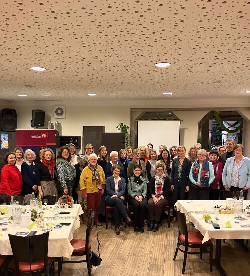 Gruppe älterer Menschen bei geselligem Treffen in einem Restaurant.